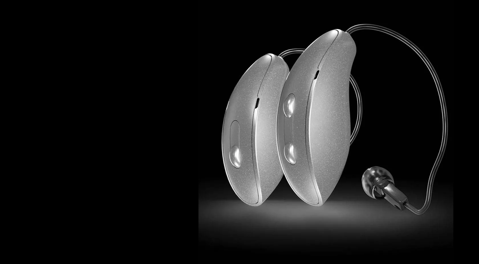 A pair of silver Starkey Omega AI hearing aids